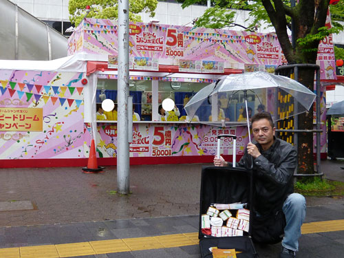 雨の中で大阪駅前第4ビル特設売場でドリームジャンボ宝くじ購入代行サービス風景