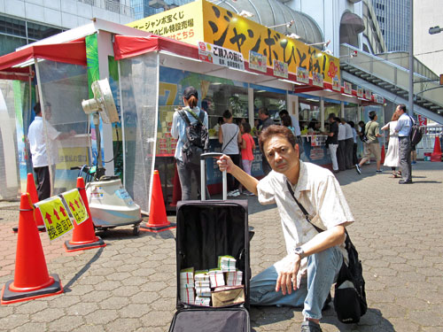大阪駅前第四ビル特設売場の前で今日買ったサマージャンボ宝くじをバックに詰めてワンショット